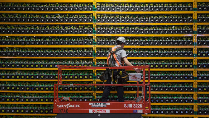 TOPSHOT - A technician inspects the backside of bitcoin mining at Bitfarms in Saint Hyacinthe, Quebec on March 19, 2018. Bitcoin is a cryptocurrency and worldwide payment system. It is the first decentralized digital currency, as the system works based on the blockchain technology without a central bank or single administrator. / AFP PHOTO / Lars Hagberg (Photo credit should read LARS HAGBERG/AFP/Getty Images)
