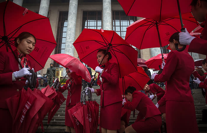 epaselect epa06272494 Chinese stewardesses carry umbrellas during rain before the opening ceremony of the 19th National Congress of the Communist Party of China (CPC) at the Great Hall of the People (GHOP) in Beijing, China, 18 October 2017. China holds the 19th Congress of the Communist Party of China, the country's most important political event where the party's leadership is chosen and plans are made for the next five years. Xi Jinping is expected to remain as the General Secretary of the Communist Party of China for another five-year term. EPA/ROMAN PILIPEY
