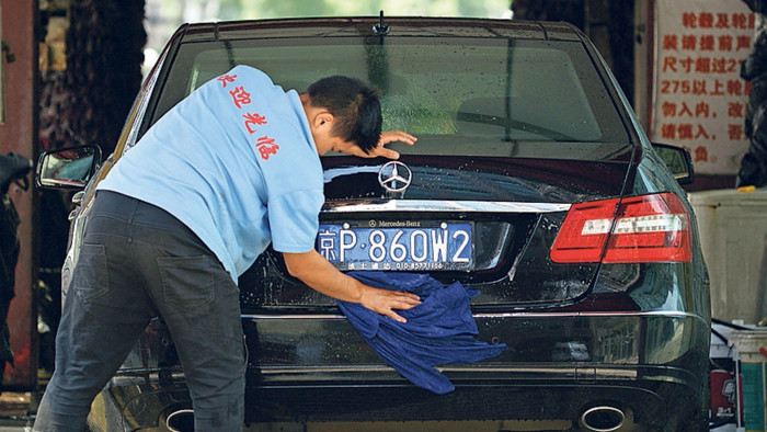 A Chinese worker cleans a Mercedes Benz at a car wash in Beijing on August 5, 2014