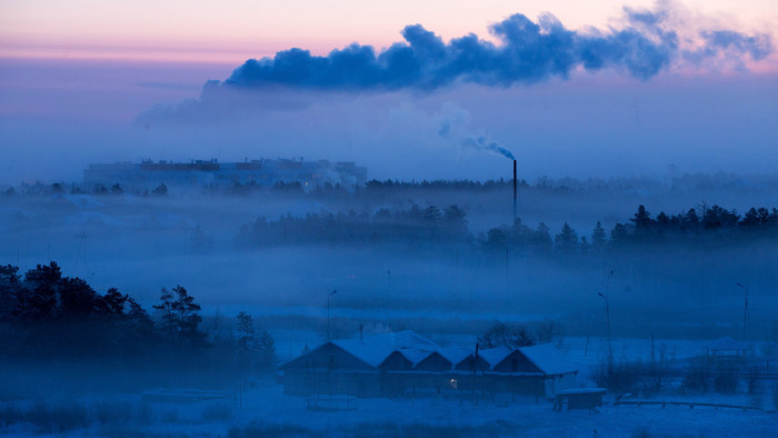 An industrial chimney emits vapor into the sky at night in Yakutsk, Sakha Republic, Russia. Photographer: Andrey Rudakov/Bloomberg