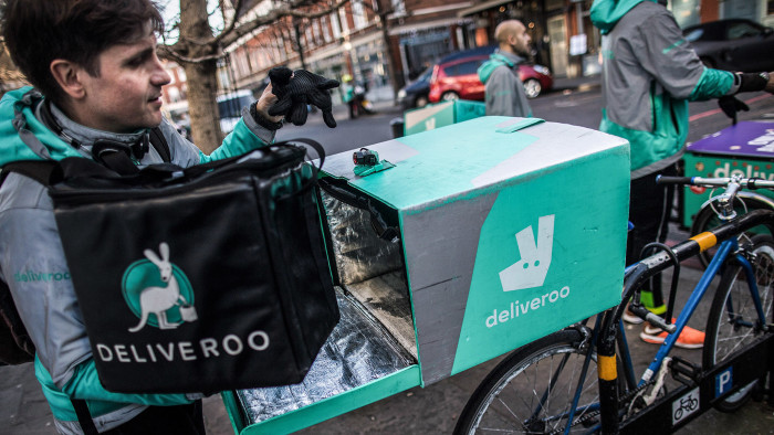 A food delivery cycle courier places an insulated bag of food into the back of his bicycle as he prepares to deliver an order from Deliveroo, operated by Roofoods Ltd., in London, U.K., on Thursday, Dec. 22, 2016. The food delivery business model has proven attractive to venture capitalists, who last year poured $5.5 billion into food-delivery companies globally, according to research firm CB Insights. Photographer: Simon Dawson/Bloomberg