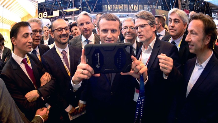 French President Emmanuel Macron (C) holds a device at the Viva Technology event dedicated to start-ups development, innovation and digital technology in Paris, France, June 15, 2017. REUTERS/Martin Bureau/Pool - RTS17957