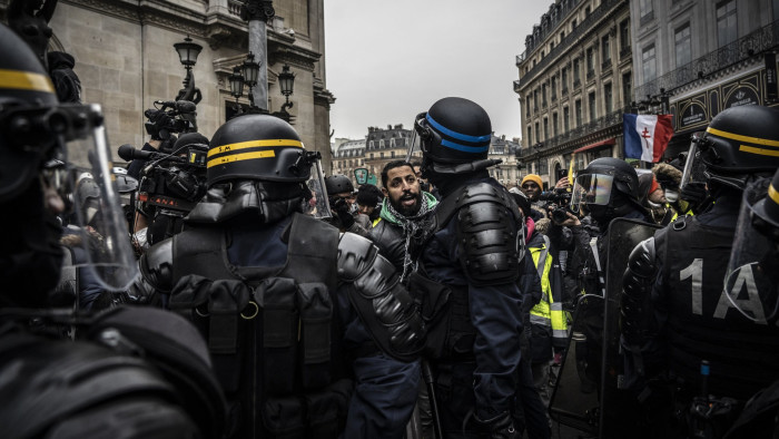 PARIS, FRANCE - DECEMBER 15: Yellow Vest protesters march in front of police on December 15, 2018 in Paris, France. The protesters gathered in Paris for a 5th weekend despite President Emmanuel Macron's recent attempts at policy concessions, such as a rise in the minimum wage and cancellation of new fuel taxes. But the 'Yellow Vest' movement, which has attracted malcontents from across France's political spectrum, has shown little sign of slowing down. (Photo by Veronique de Viguerie/Getty Images)