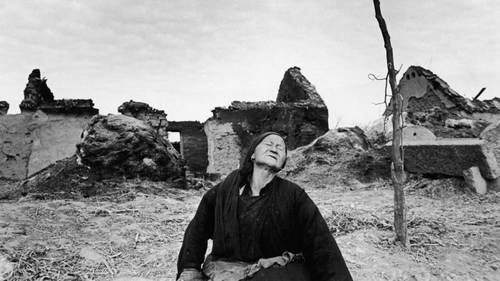 A grief-stricken woman in the ruins of a village destroyed by fighting during the Chinese civil war, 1948