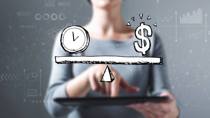 Time and money on the scale with business woman using a tablet computer