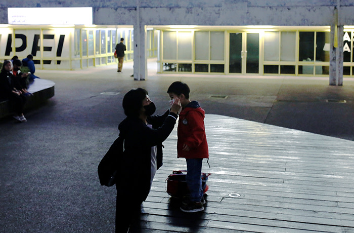 An adult helps to put a face mask on a child's face for protection due to the coronavirus disease (COVID-19) outbreak in Taipei, Taiwan, March 31, 2020. REUTERS/Ann Wang - RC23VF9T4FV4