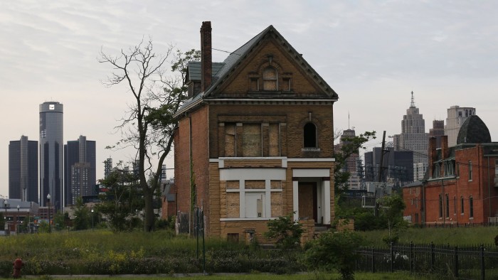 A boarded up vacant home is seen with General Motors World Headquarters (L) and the Detroit skyline June 10, 2014. REUTERS/Rebecca Cook (UNITED STATES - Tags: TRANSPORT BUSINESS) - RTR3T24M
