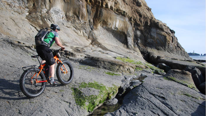 Joe Kidd takes his fatbike over some rocky outcrops on the Oregon coast