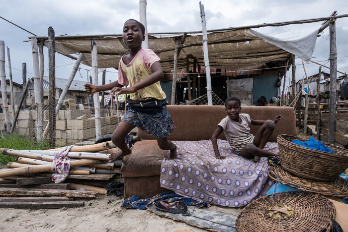 In the informal fishing community of Isale Ijebu in Ajah lagos, a child jumps from a sofa onto the sand