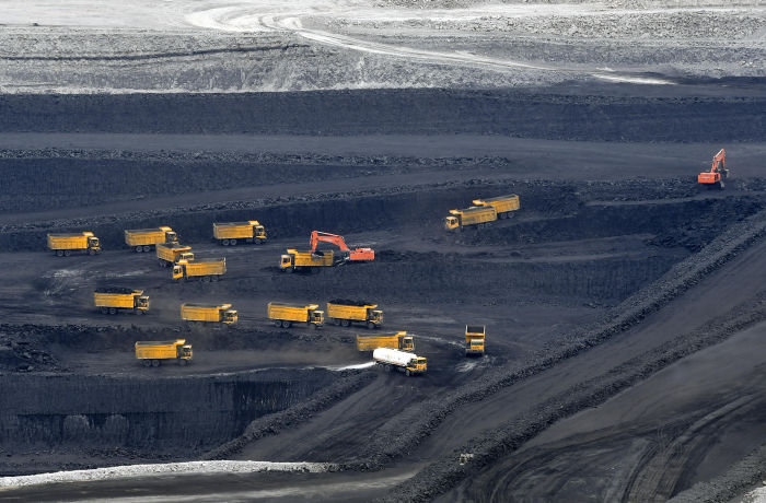 CHANGJI, CHINA - JULY 04: Transport trucks transfer raw coal in pits as deep as 200 meters at the East Junggar Basin on July 4, 2018 in Changji Hui Autonomous Prefecture, Xinjiang Uyghur Autonomous of China. The East Junggar Basin as one of the largest coalfield in Xinjiang has predicted coal reserves of 390 billion tons. (Photo by Liu Xin/China News Service/Visual China Group via Getty Images)