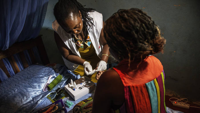 A medic with Doctors Without Borders (MSF) tests for HIV a sex worker in her room along the Beira "corridor" on October 17, 2014 in Beira, Mozambique. The Beira corridor is a strip of land running from the Indian Ocean port of Beira, Mozambique's second city, to Zimbabwe's eastern border. The World Health Organization (WHO) says there were some 35 million people around the world living with HIV by the end of 2013, with some 2.1 million new infections during the course of that year. Sub-Saharan Africa is the most affected region, with almost 70 percent of new infections. AFP PHOTO/GIANLUIGI GUERCIA (Photo credit should read GIANLUIGI GUERCIA/AFP via Getty Images)