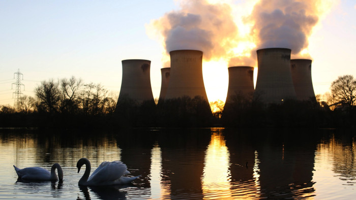 Swans swim on a lake close to Drax Power Station, operated by Drax Group Plc, in Selby, U.K., on Tuesday, March 11, 2014. Drax Group Plc, the operator of the U.K.'s biggest coal-fired power station, reported a 23 percent slump in full-year profit as carbon prices rose and it prepared to convert two more units to burn cleaner fuel. Photographer: Chris Ratcliffe/Bloomberg