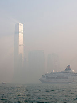 Haze surrounds the International Commerce Centre (ICC), center, as a cruise ship sails past in Hong Kong, China, on Monday, April 15, 2013