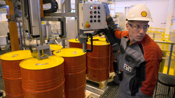 Oil Declines Below 60USD A Barrel...FILE PHOTO: An employee holds a control panel as barrels are filled with lubricant oil ahead of shipping at Royal Dutch Shell Plc's lubricants blending plant in Torzhok, Russia, on Friday, March 21, 2014. Oil extended losses below $60 a barrel amid speculation that OPEC's biggest members will defend market share against U.S. shale producers. Photographer: Andrey Rudakov/Bloomberg