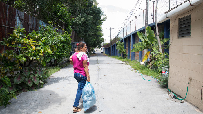 Maribel carries her grandson as she goes to visit her daughter in a juvenile detention centre in San Salvador