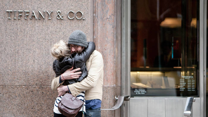 A couple embraces in front of a Tiffany & Co. store in New York, U.S., on Thursday, March 15, 2012. Tiffany & Co., the world's second-largest luxury jewelry retailer, is expected to release earnings next week. Photographer: Scott Eells/Bloomberg