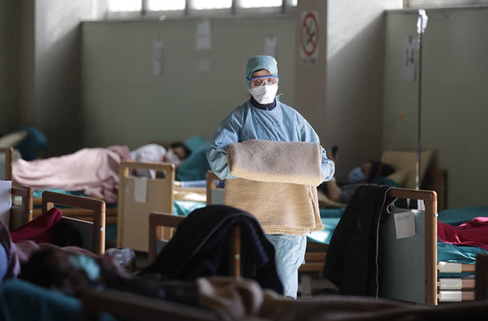 Medical staff work at one of the emergency structures that were set up to ease procedures at the Brescia hospital, northern Italy, Monday, March 16, 2020. For most people, the new coronavirus causes only mild or moderate symptoms. For some, it can cause more severe illness, especially in older adults and people with existing health problems. (AP Photo/Luca Bruno)