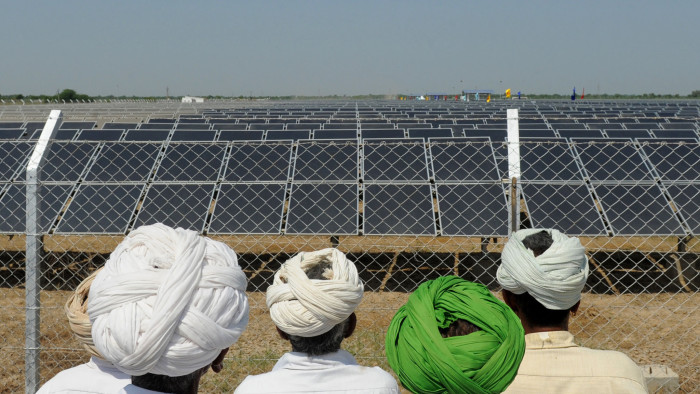 Indian villagers look at solar panels during the inauguration of a solar farm in the village of Gunthawada, Banaskantha district, some 175kms. from Ahmedabad on October 14, 2011. Chief Minister of the western Indian state of Gujarat Narendra Modi inaugrated the 30MW solar farm - said to be Asia's largest - which has been set up by Moser Baer Clean Energy. AFP PHOTO/Sam PANTHAKY (Photo credit should read SAM PANTHAKY/AFP/Getty Images)