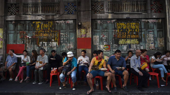 TOPSHOT - People sit and eat a meal on a side-walk in Bangkok's Chinatown on February 4, 2016. AFP PHOTO / Christophe ARCHAMBAULT / AFP / CHRISTOPHE ARCHAMBAULT (Photo credit should read CHRISTOPHE ARCHAMBAULT/AFP via Getty Images)