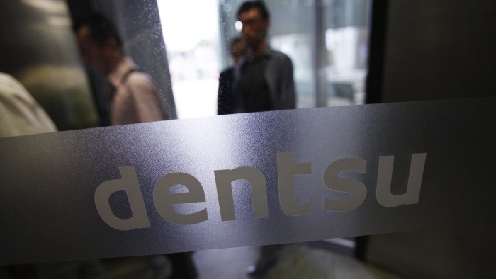 The logo of Dentsu Co. is seen at the entrance of the company headquarters in Tokyo...The logo of Dentsu Co. is seen at the entrance of the company headquarters in Tokyo July 12, 2012. Japanese ad giant Dentsu is buying marketing group Aegis for 3.2 billion pounds ($5 billion), the biggest deal in its history as it seeks to expand outside its home market with the British firm's European and digital business. REUTERS/Issei Kato (JAPAN - Tags: MEDIA BUSINESS LOGO)