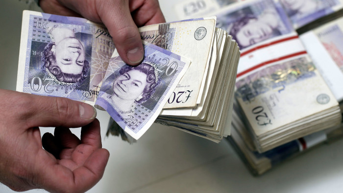 An employee manually counts 20 pound sterling banknotes in this arranged photograph inside a Travelex store, operated by Travelex Holdings Ltd., in London, U.K., on Friday, Sept. 12, 2014. The pound, already suffering its worst month in more than a year, has the potential to tumble 10 percent should the Scots vote for independence from the U.K., according to economists surveyed by Bloomberg. Photographer: Matthew Lloyd/Bloomberg