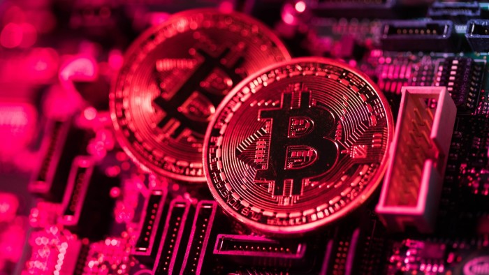 Two coins representing Bitcoin cryptocurrency sit on a computer circuit board in this arranged photograph in London, U.K., on Tuesday, Feb. 6, 2018. Cryptocurrencies tracked by Coinmarketcap.com have lost more than $500 billion of market value since early January as governments clamped down, credit-card issuers halted purchases and investors grew increasingly concerned that last year’s meteoric rise in digital assets was unjustified. Photographer: Chris Ratcliffe/Bloomberg
