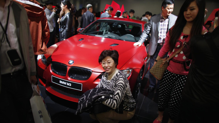 A woman poses for a picture next to a BMW M3 car during the 15th Shanghai International Automobile Industry Exhibition in Shanghai April 21, 2013. BMW, the world's biggest luxury carmaker, said it is targeting &quot;upper single-digit&quot; sales growth in China this year, a senior company official said on Saturday. REUTERS/Carlos Barria (CHINA - Tags: BUSINESS TRANSPORT) - RTXYU9Y