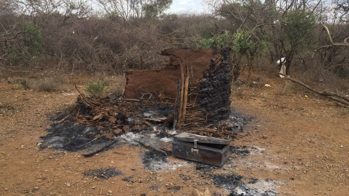 Kenya Rift Valley Chepkalacha, the village in Baringo Country allegedly attacked by police on Monday. The group is some of the villagers who took me on a tour of the village. The flattened corrugated iron is a destroyed house while the other, burnt out building, was a food store