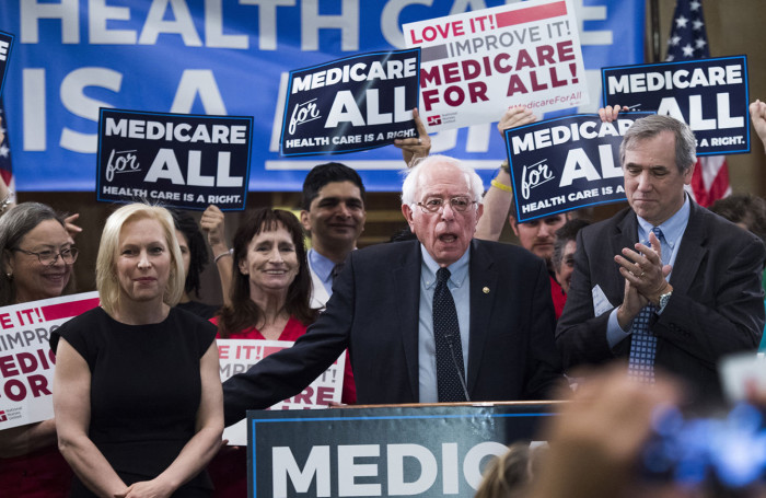 UNITED STATES - APRIL 10: From left, Sens. Kirsten Gillibrand, D-N.Y., Bernie Sanders, I-Vt., and Jeff Merkley, D-Ore., conduct an event to introduce the "Medicare for All Act of 2019" in Dirksen Building on Wednesday, April 10, 2019. (Photo By Tom Williams/CQ Roll Call)
