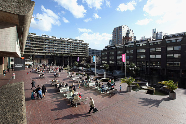People sit outside The Barbican arts and residential centre in London