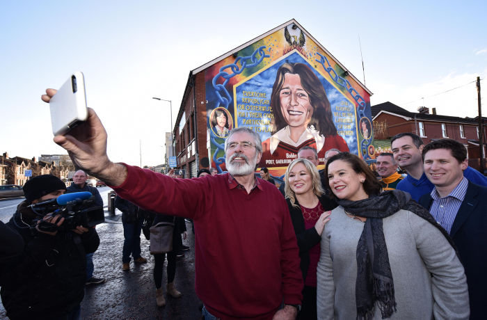 BELFAST, NORTHERN IRELAND - MARCH 04: Sinn Fein President Gerry Adams (L), southern leader Mary Lou McDonald (R) and northern leader Michelle O'Neill (C) take a selfie in front of the Bobby Sands mural as they hold a post election press conference at Sinn Fein headquarters on March 4, 2017 in Belfast, Northern Ireland. Sinn Fein increased their vote significantly in yesterday's Northern Ireland Assembly snap election and for the first time Stormont will not feature a Unionist majority in government. The Democratic Unionist party, who were implicated in the Renewable Heat Incentive scheme scandal suffered a damaging loss but remain the number one party in the province albeit with a slim majority of just one seat. (Photo by Charles McQuillan/Getty Images)