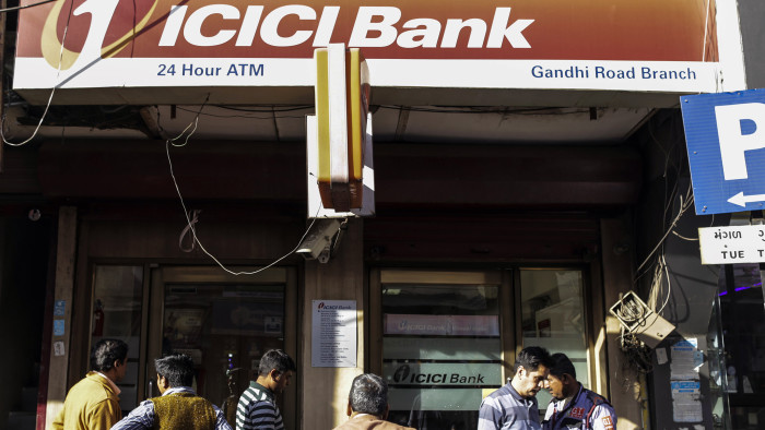 Customers stand outside an ICICI Bank branch in the Gandhi Road area of Ahmadabad, Gujarat, India, on Monday, Dec. 14, 2015. India's rupee is feeling the heat as the Federal Reserve looks set to raise interest rates for the first time in a decade. The currency, touted as Asia's most resilient to a U.S. rate increase by Australia & New Zealand Banking Group Ltd., has extended declines in December after weakening 2.1 percent last month in the region's worst performance. Photographer: Dhiraj Singh/Bloomberg