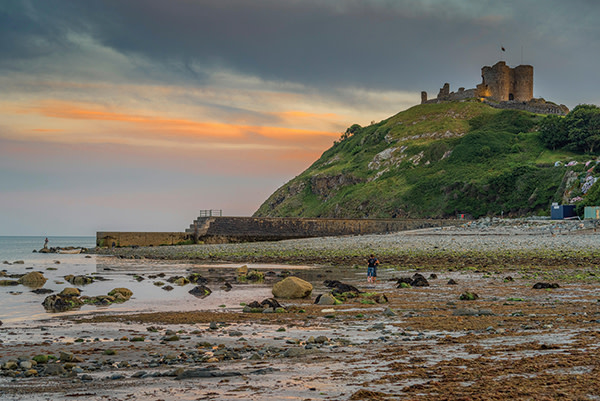 The pebbly shoreline of cricieth, with its hilltop castle