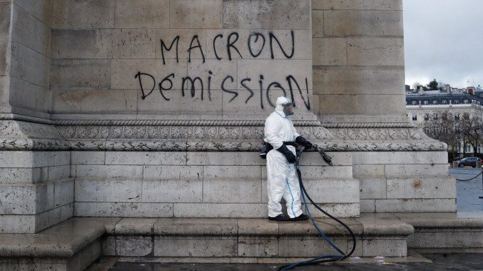 A worker is about to clean a graffiti reading &quot; Macron resignation&quot; on the Arc de Triomphe the day after a demonstration, in Paris, Sunday, Dec. 2, 2018. A protest against rising taxes and the high cost of living turned into a riot in the French capital, as activists torched cars, smashed windows, looted stores and tagged the Arc de Triomphe with multi-colored graffiti. (AP Photo/Thibault Camus)