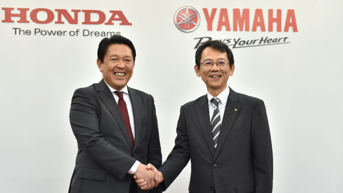 Honda Motor Operating Officer and Director Shinji Aoyama (L) shakes hands with Yamaha Motor Managing Executive Officer and Director Katsuaki Watanabe (R) following their joint press conference in Tokyo on October 5, 2016. Japan's Honda Motor and Yamaha Motor will join forces in motorcycle production and development, a move that will see Honda manufacturing scooters for its biggest rival in a shrinking domestic market. / AFP PHOTO / KAZUHIRO NOGIKAZUHIRO NOGI/AFP/Getty Images