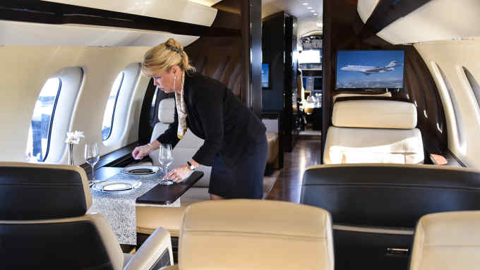 An employee arranges a table inside a Bombardier Inc. Global 7000 Business Jet aircraft during the NBAA Business Aviation Convention & Exhibition (BACE) in Orlando, Florida, U.S., on Tuesday, Nov. 1, 2016. The NBAA-BACE, ranked as the sixth largest trade show in the United States, joins 27,000 industry professionals for the three days of business aviation. Photographer: Mark Elias/Bloomberg