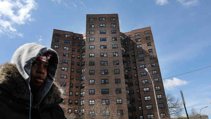NEW YORK, NY - MARCH 16: A woman walks by the Farragut Houses, a public housing project in Brooklyn on March 16, 2017 in New York City.The budget blueprint President Donald Trump released Thursday calls for the cutting of billions of dollars in funding from the Department of Housing and Urban Development. This is despite a campaign pledge Trump made to help rebuild the nation's inner city communities. (Photo by Spencer Platt/Getty Images)