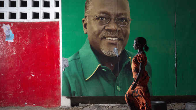 A woman walks past an election billboard after ruling party Chama Cha Mapinduzi (CCM) candidate John Magufuli (pictured on the billboard) was named president-elect by the National Electoral Commission in Dar es Salaam, on October 29, 2015