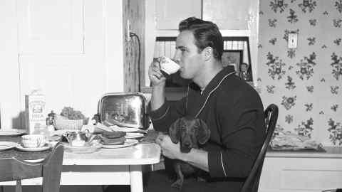 American actor Marlon Brando (1924 - 2004) smokes and drinks from a tea cup at the table in his grandmother?s house, Van Nuys, California, October 1949. (Photo by Ed Clark/The LIFE Picture Collection via Getty Images)