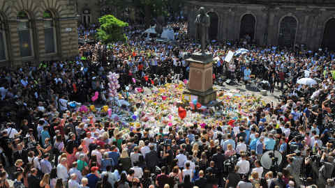 People attend a one minute silence to the victims of Monday's explosion at St Ann's Square in Manchester, England Thursday May 25 2017.  More than 20 people were killed in an explosion following a Ariana Grande concert at the Manchester Arena late Monday evening