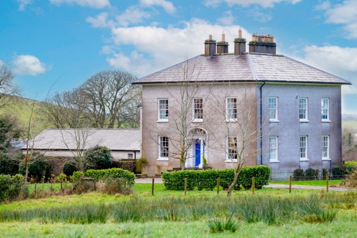 a large grey traditional-looking detached house in the Northern Irish countryside