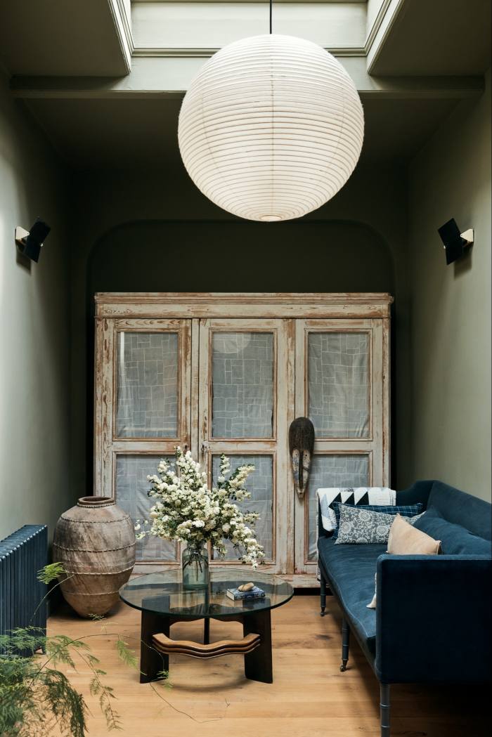 The entrance hall, painted in Tirzah, with a sofa designed by Ellis and a coffee table by Osvaldo Borsani