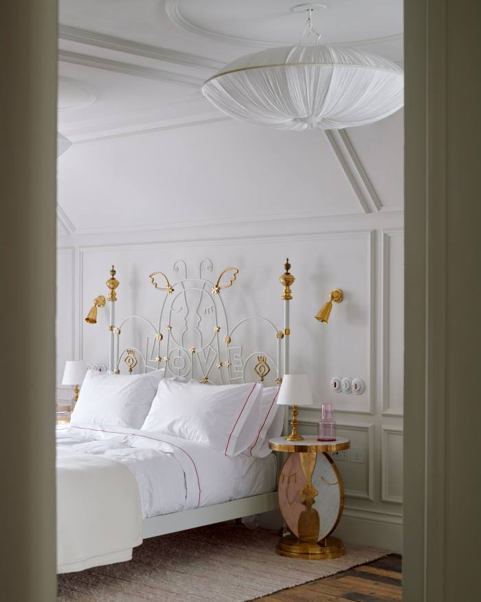 The “love” bedroom, with a Charlotte Colbert bed and Buchanan Studio x Charlotte Colbert Kiss bedside tables. The throw and wall lights are by Rose Uniacke. The rug is from Sacco