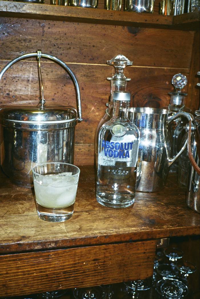 The bar cupboard, with a bottle of vodka, ice bucket, jug and carafe