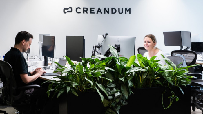 A man and a woman working at computers in a Creandum office