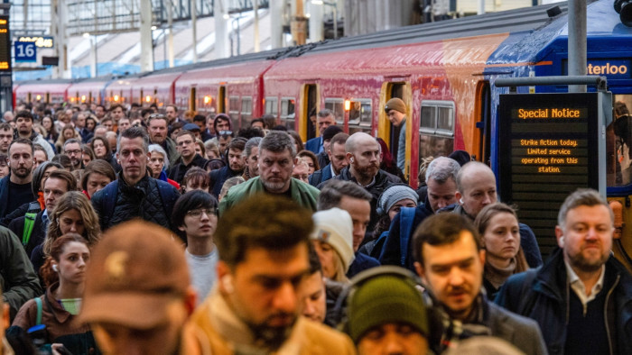 Commuters disembark a train in the morning rush hour, during a train drivers strike over pay, at London Waterloo 