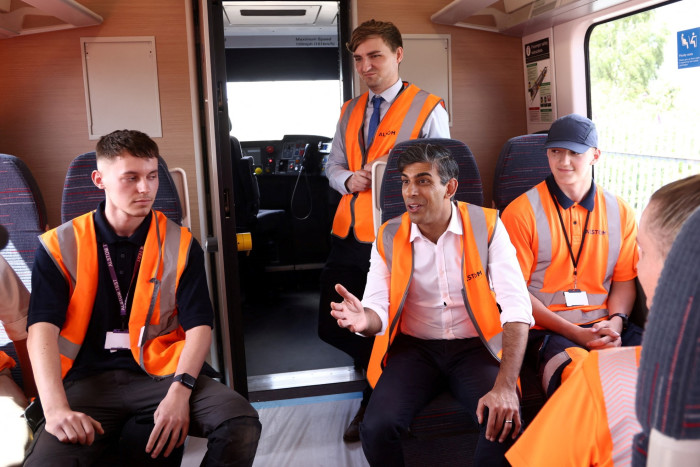 Britain’s Prime Minister and Conservative Party leader Rishi Sunak speaks to apprentices inside a new train during a visit to Alstom Transport in Derby