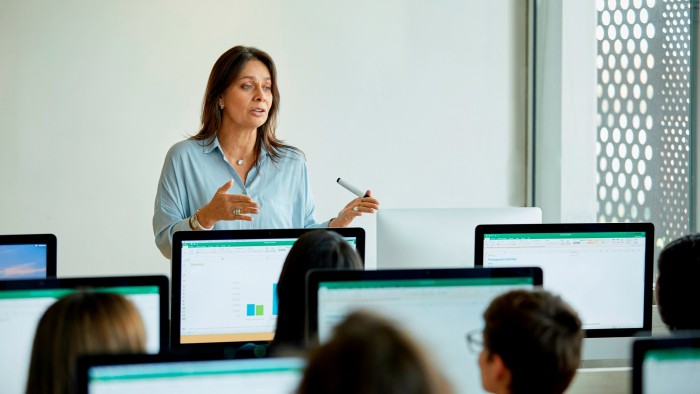 Female teacher teaching university students sitting in a classroom