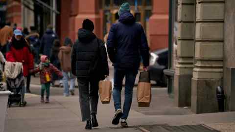 Pedestrians carry shopping bags in New York, US