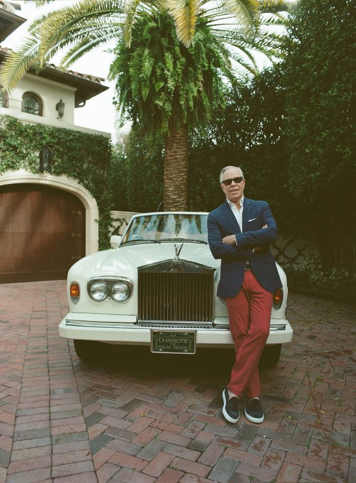 Tommy Hilfiger leans on the bonnet of his white Rolls-Royce Corniche